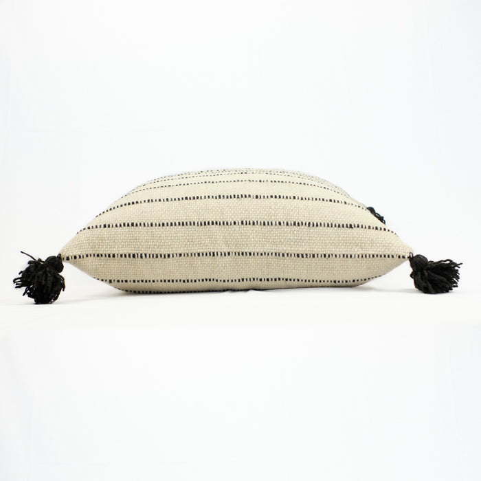 Natural wool pillow in cream with black stripes and black poms by Treko Wool.