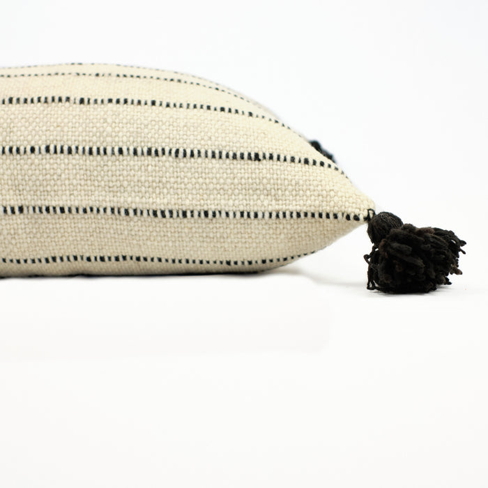 Natural cream colored pillow with black stripes and black poms by Treko Wool.
