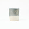 Small cream colored ceramic cup dipped in a blue-grey glaze by Totem Home.