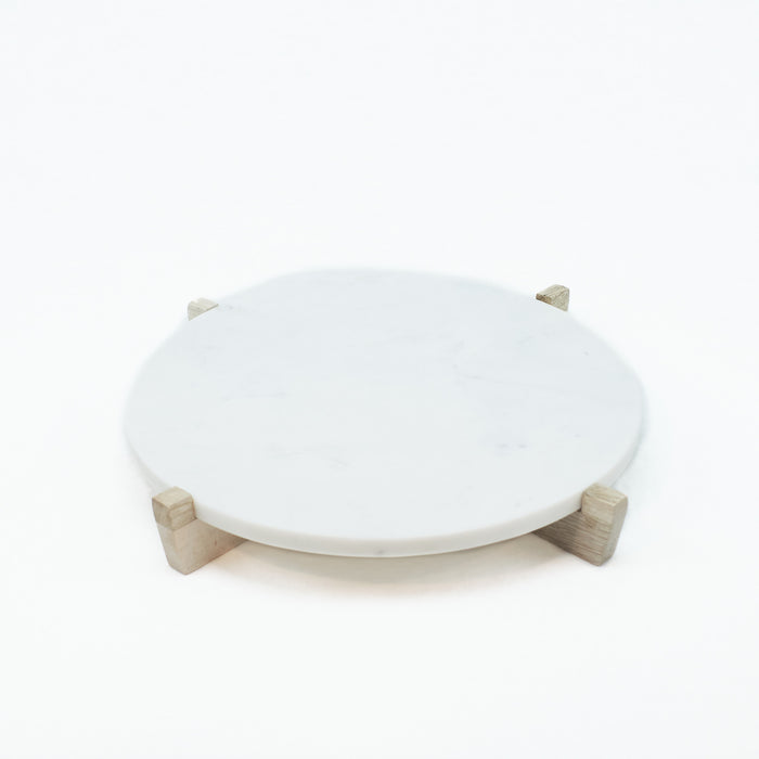 Round white marble serving board/platter on natural mango wood stand. Measures 14" diameter, 1/2" thick, 2" high on stand. 