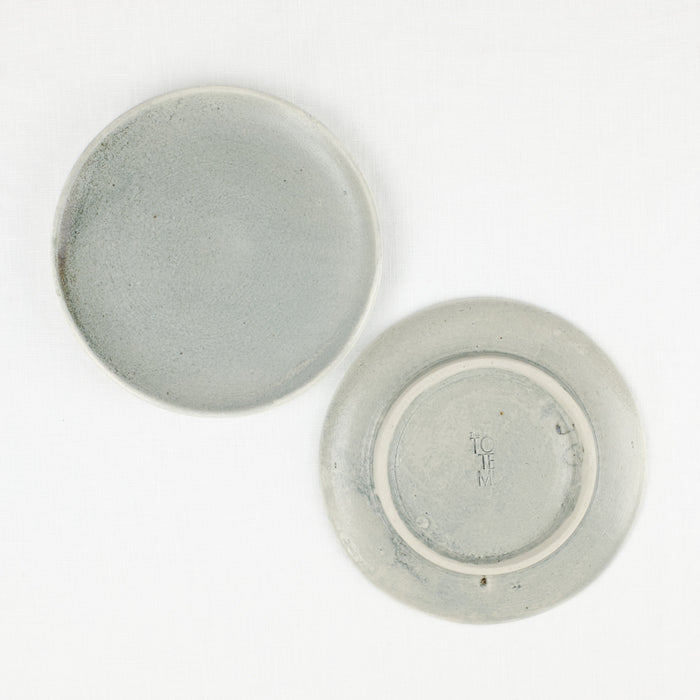 Top and bottom view of small ceramic plate by Totem Home. Hand made ceramic plate with blue-grey glaze.