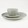Smoke ceramic table setting by Totem Home. Shows dinner plate, side plate and bowl in blue-grey glaze.