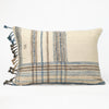Cream throw pillow with blue, tan and brown plaid pattern and blanket fringe trim