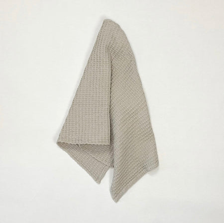 Simple waffle hand towel in light grey. Made in Portugal of 100% cotton. Measures 19 x 39 inches.