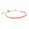 Coral 9 friendship bracelet woven in a soft shade of coral pink and finished with tiny brass beads. Pull string adjuster, one size fits most.
