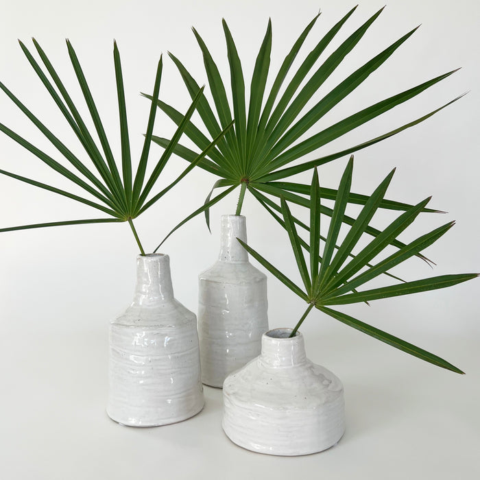 Collection of 3 white Mediterranean vessels with palm fronds. Size medium, tall and wide shown, each sold separately. Organic ceramic vases finished in a thick, white, glossy glaze.