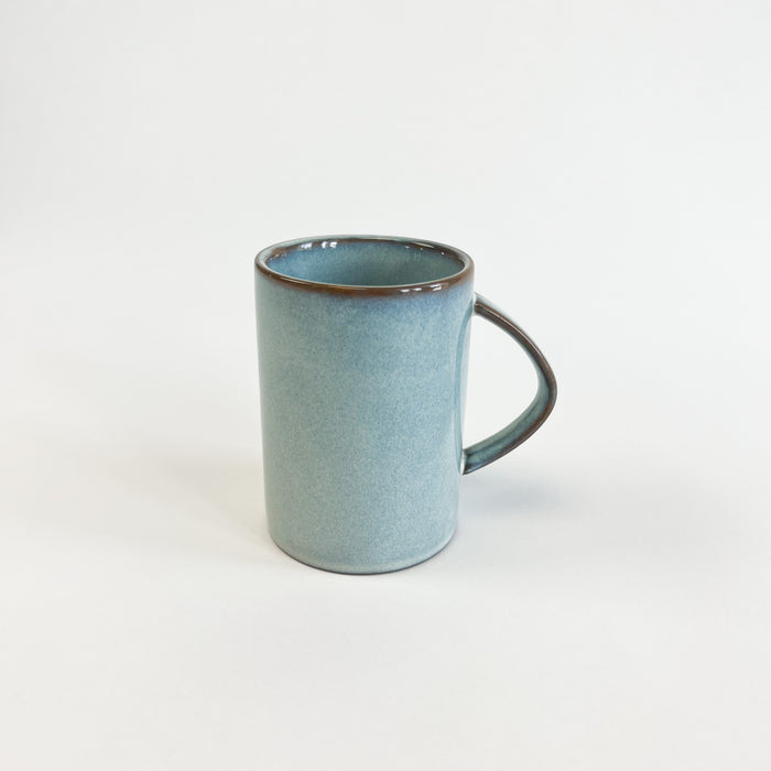Azure ceramic mug. Finished in a watery blue glaze with accents of sepia. Perfect for the coastal kitchen. Measures 4" high, 2.75" diameter. Dishwasher and microwave safe.