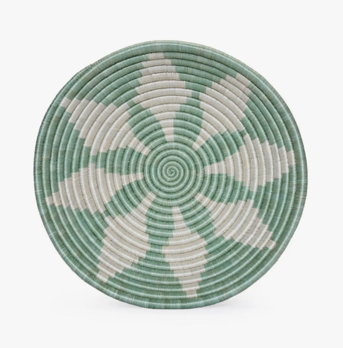 Basket bowl  in sea foam green with white geometric floral design. Hand woven by skilled artisans in Uganda using hand dyed sweet grass and raffia. 12" diameter. 