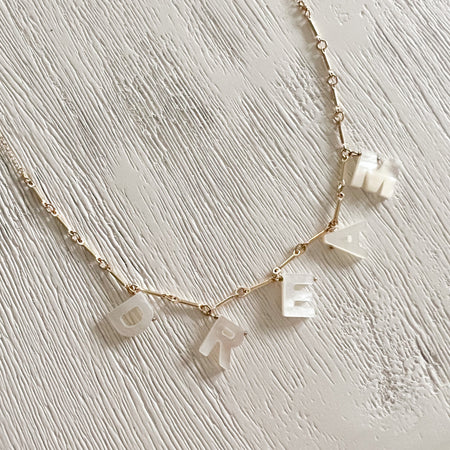 The Dream necklace is a reminder that we should all dare to dream. Hand carved mother of pearl letters on a 14K gold filled chain. A great gift for the graduate. Adjustable length from 16 to 18 inches.