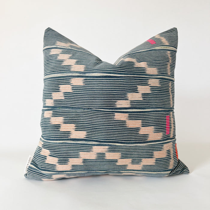 Square Amara pillow made in authentic Baule cloth. Fine indigo and natural stripes with a soft pink zig zag pattern. Hand stitched blocks in fuchsia and orange decorate the right side. Natural Belgian linen back. Measures 20" x 20". Limited edition.