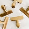 Brass clips. Stylish way to store things in office or pantry. Made of stainless steel with a brass finish. Sold individually. 3" across, 2.5" tall