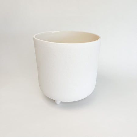 Small adobe footed vessel. Ceramic vessel finished with a matte white glaze similar to natural adobe. Perfect for adding  boho chic or modern mediterranean style to your room or patio. Small vessel measures 8" high 7.5" diameter.