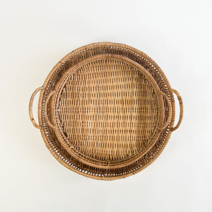 Pair of Roundhill rattan trays shown stacked together. Each tray is hand woven from natural rattan. A great way to add tropical style to any room. Each tray is sold separately. 
