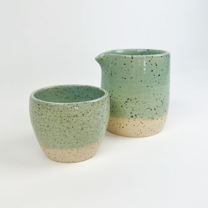 Chibiko cup in the seafoam glaze shown with the coordinating Chibiko Carafe. Coastal inspired ceramics hand crafted by Tamiko Claire Studios in Hawaii. Each sold separately.