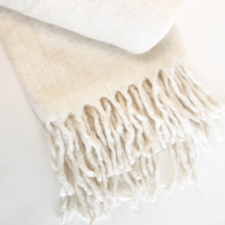 The Fireside throw in a luxe wool blend is brushed for an airy and soft handfeel. Ends are finished with long fringe ends. A luxe layer for the neutral home. Measures 50" x 65".