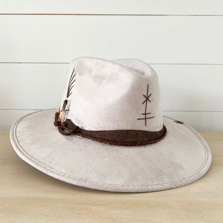 Peace Hat made in pale taupe suede. Brim is wrapped with a chocolate brown suede strap, coffee colored twine and finished with a clear crystal and a small piece of Polo Santo wood. Hand stitched symbols adorn the crown. Boho chic style. Measures 58 cm/22 inches around crown.