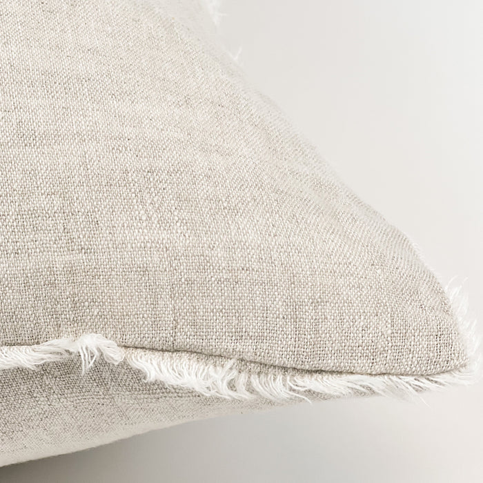 The linen fringe pillow in oat chambray. All four edges are finished with a natural linen fringe for added texture. Luxe proportion of 24" square is filled with a soft down insert. Perfect for the natural and neutral home.