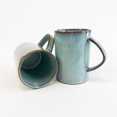 Pair of Azure mugs shown. Each sold separately. Dishwasher and microwave safe. Coastal inspired  with a soft blue glossy glaze and touches of sepia showing through on the edges. Perfect for the coastal kitchen.  Measures 4" high, 2.75" diameter.