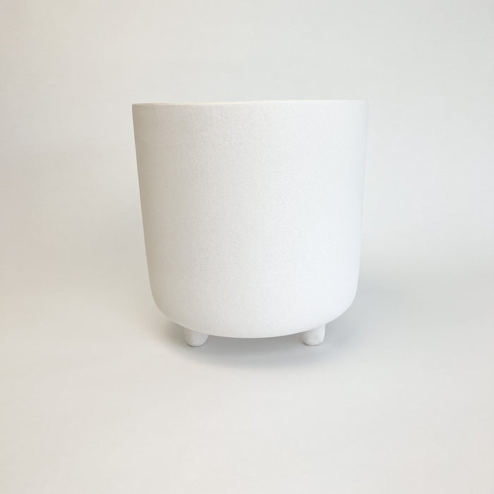 Medium adobe footed vessel. Ceramic pot finished with a matte white glaze similar to natural adobe. Add modern Mediterranean or boho chic style to your room or patio. Medium measures 9.25" high 9" diameter.