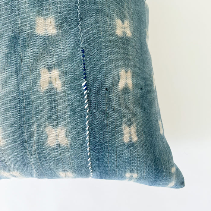 Close up detail of vertical hand mending in cobalt and white thread on pattern "shibori 2.0", square Zola pillow.