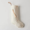 Ivory linen Christmas stocking with cotton lining. Natural leather hanger loop. Hand stamped leather tag "Merry". 