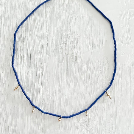 The Athena necklace. Handcrafted in the USA using lapis blue beads and delicate gold plated charms. Boho chic jewelry. Fits close to the neck as a choker, measuring an adjustable 15 to 17 inches. 