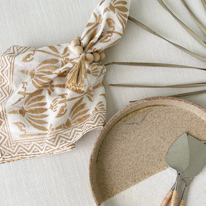 Gold Palm block print bandana shown used as a table napkin paired with the Hamptons napkin ring. Perfect for the boho chic table. Each item sold separately.