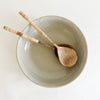 Stoneware Bayside serving dish shown with wood serving pieces with rattan handle. Each sold separately. Organic texture for the coastal or farmhouse table.