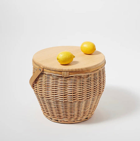 Wicker and rosewood beach picnic basket and cooler. Natural rosewood lid acts a tabletop and cheese board while all wicker base has an insulated interior perfect for keeping beverages chilled. Made by Australian brand Sunnylife. 13" height, 15" diameter.