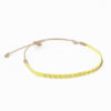 Citron 5 woven friendship bracelet in a day glow shade of lemon yellow. Embellished with tiny brass beads. Pull string adjuster, one size fits most.