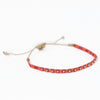 Guava 6 friendship bracelet woven in fuchsia and orange stripes and embellished with tiny brass beads. Pull string adjuster, one size fits most.