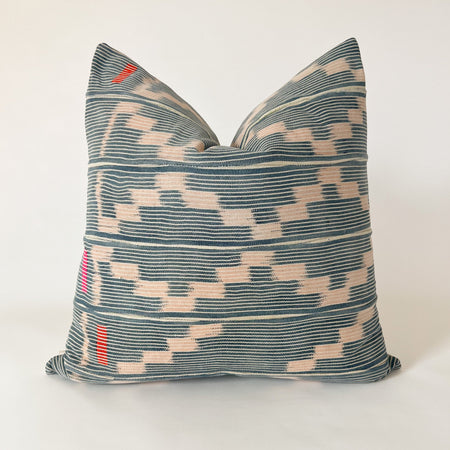 Square Amara pillow made from authentic Baule cloth. Fine indigo and natural stripes with a pale pink zig zag pattern. Hand stitched blocks in orange and fuchsia accent the left side. Natural Belgian linen back. Measures 20" x 20". Limited edition.