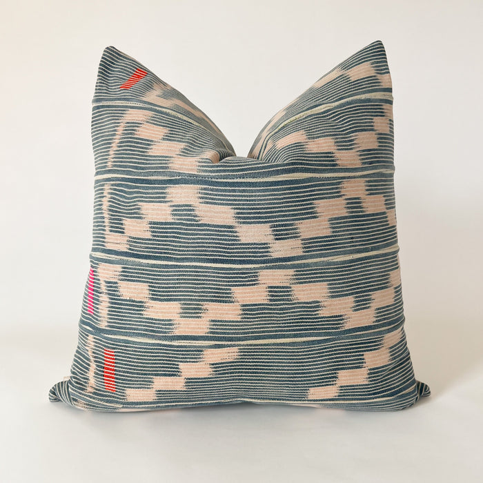 Square Amara pillow made from authentic Baule cloth. Fine indigo and natural stripes with a pale pink zig zag pattern. Hand stitched blocks in orange and fuchsia accent the left side. Natural Belgian linen back. Measures 20" x 20". Limited edition.