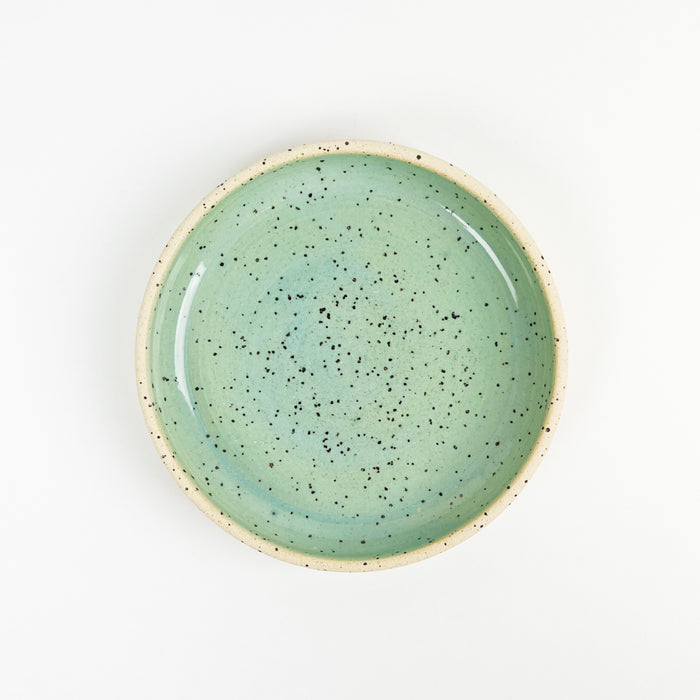 Momo dish in seafoam glaze. Coastal inspired stoneware made by Tamiko Claire's studio in Hawaii. Each piece is hand crafted. The small proportion is perfect for use as a jewelry or trinket dish or used to serve a favorite sweet treat. Measures 6.25" diameter 1" height.