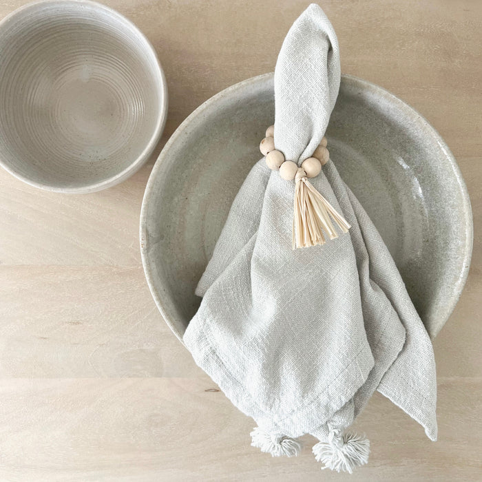 Boho coastal table setting. Tassel napkin in sea mist shown styled with Hampton napkin ring and Bayside stoneware. All pieces sold individually.