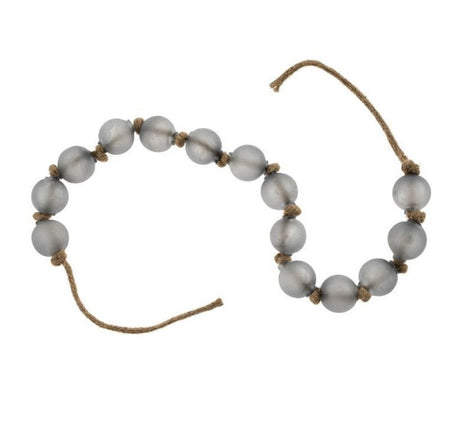 Strand of fog grey beach glass balls knotted together on jute twine. Measures 34" end to end. Each ball is 1.25" diameter.