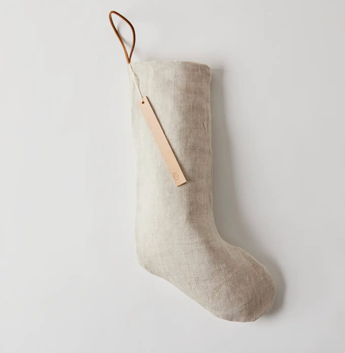 Oatmeal linen Christmas stocking with cotton lining. Natural leather hanger loop. Hand stamped leather tag with "Fa La La".