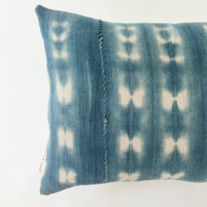 Close up mending detail on shibori 1.5 pattern of the small Zola pillow.  Light blue and navy hand mending. Faded indigo and natural shibori "tie dye".