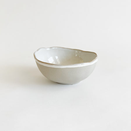 Small Shoreline bowl. Hand shaped ceramic bowl with a matte grey glaze exterior and glossy white interior. The organic form inspired by the shape of shells & pebbles. Decorative accent for the coastal home. 4" diameter, 2" height. 