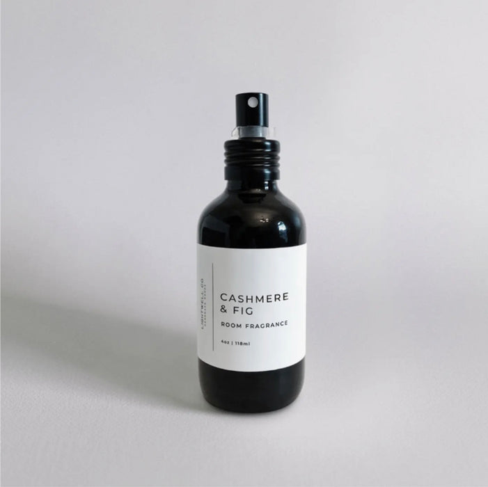 Bottle of Cashmere & Fig room spray. 4 oz. black opaque glass bottle with modern white label. Fragrance notes: fresh fig leaves, white cedar wood and cashmere musk.