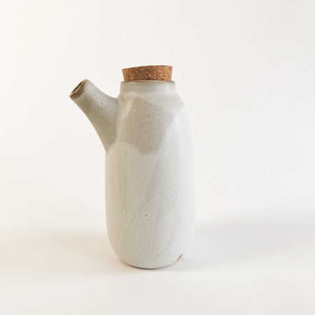 Stoneware carafe finished with a matte glaze in a swirl of white and grey. Perfectly proportioned for serving salad dressing or syrup. Cork stopper keeps contents fresh. Measures 6" height, 3" diameter.