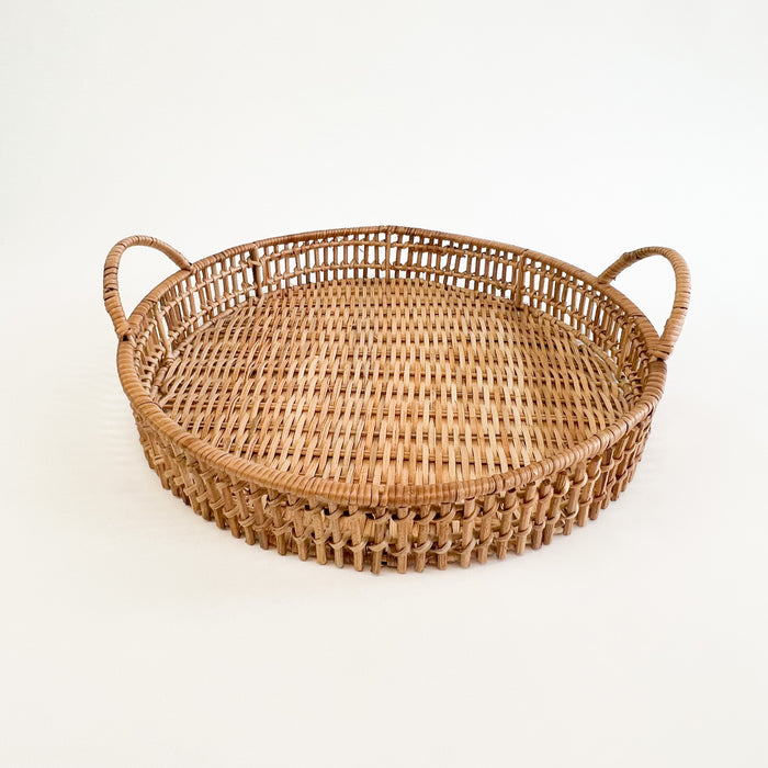Small Roundhill tray is handwoven using natural rattan. Small measures 14" diameter 2.25" height. The small tray nests with the larger size tray for a stylish and tropical tabletop display. Each sold separately.